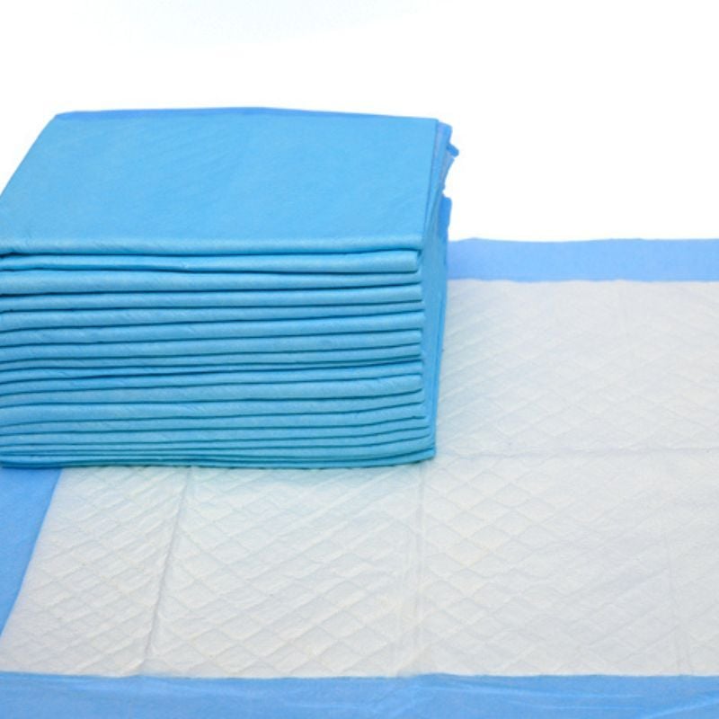 Stack of blue and white bed bladder underpads.