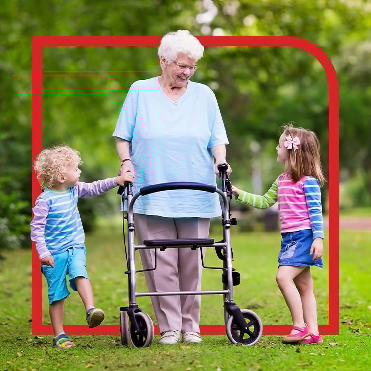 Grandmother using walker smiles at two young girls while supported by APA Medical equipment