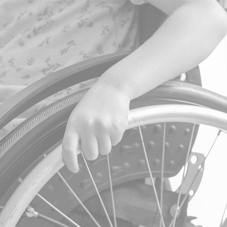 Close-up of patient’s hand pushing wheelchair wheel while moving forward